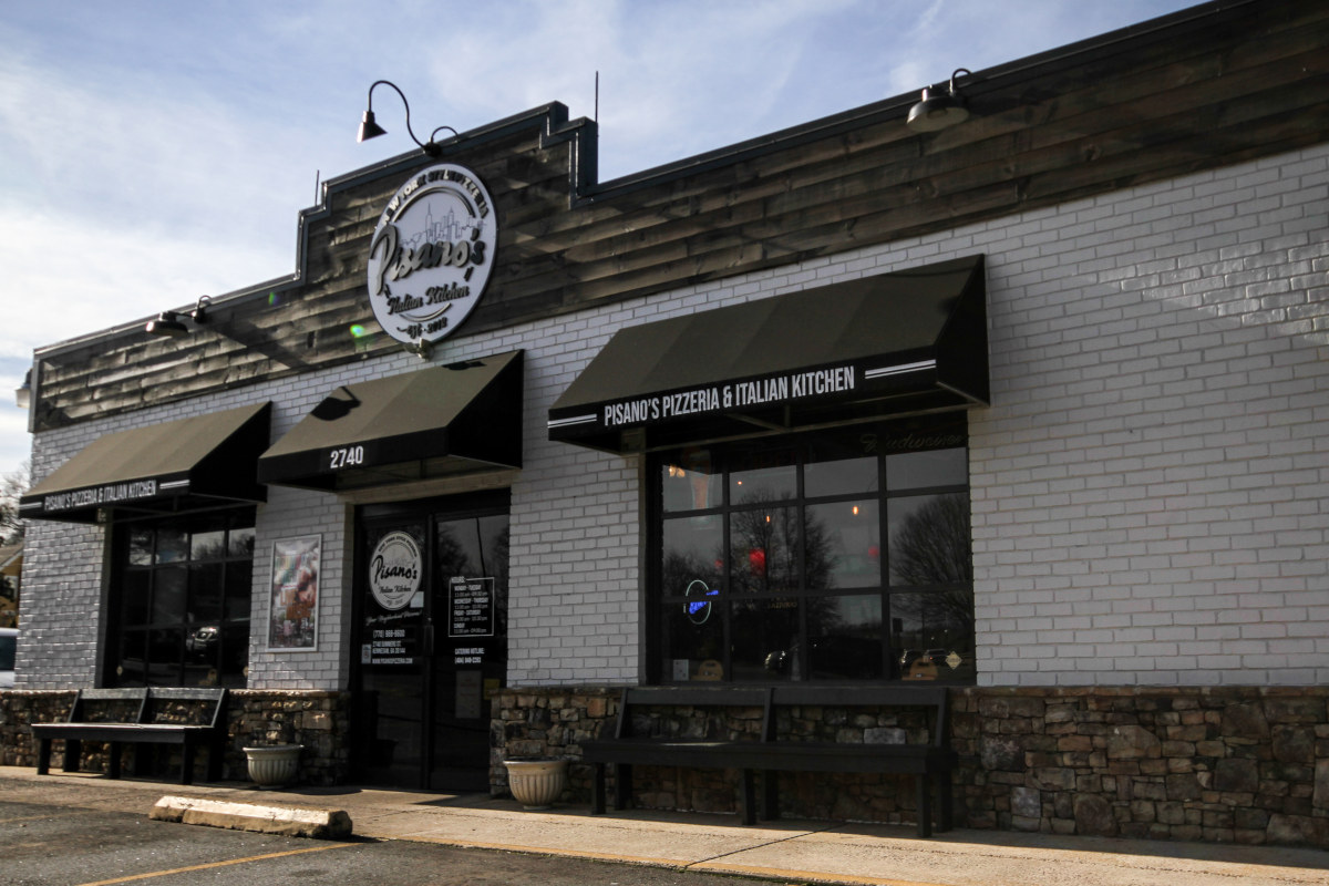 The Pisano's storefront on Summers Street with black awnings and the round sign